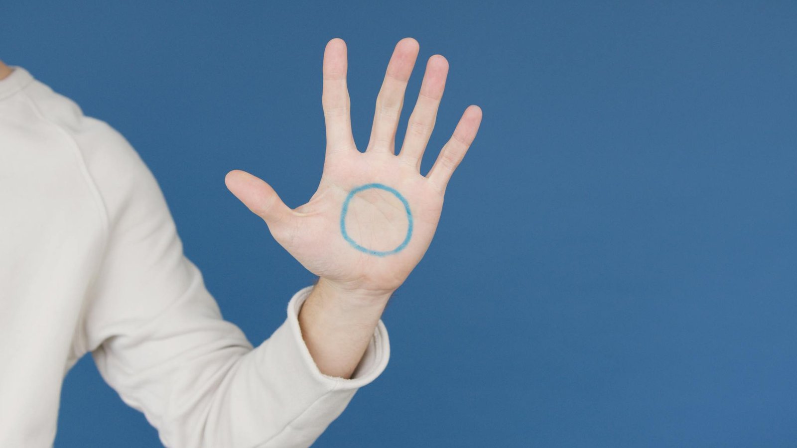 Close-up of a hand with a blue circle drawn on the palm symbolizing diabetes awareness.